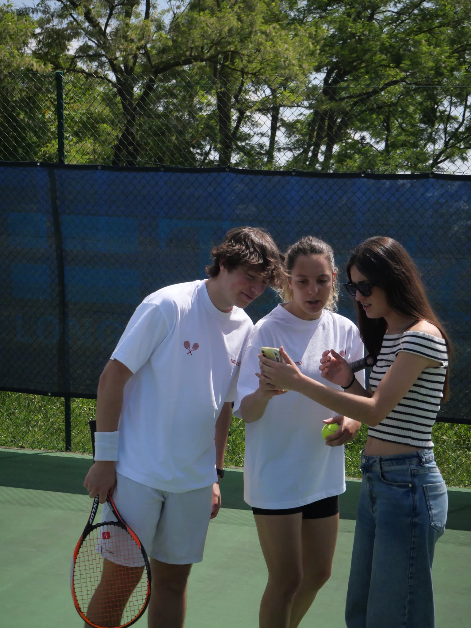 Equipo de Santofimia mirando fotos del rodaje de On Court en una pista de tenis de París